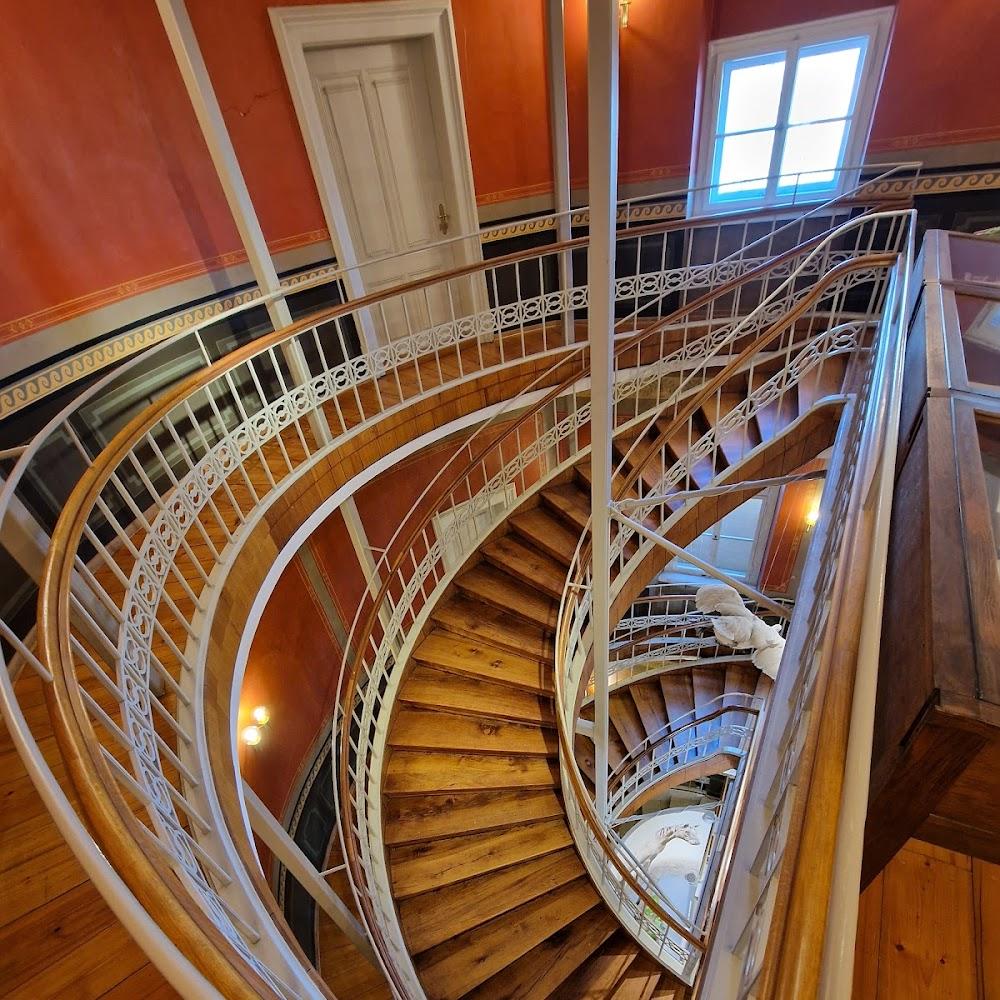 Spiral staircase with white railing in a building.